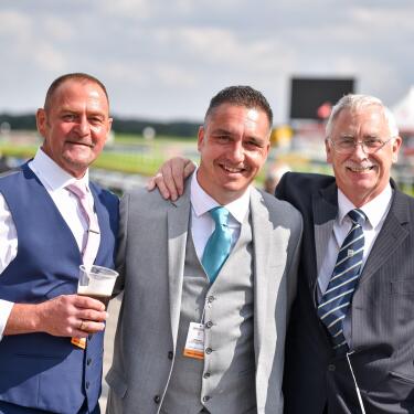 A group of smartly dressed gentlemen at the races