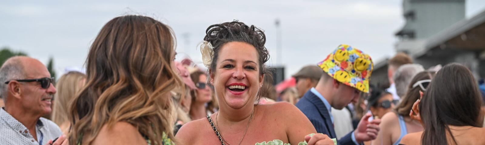 A race goer smiling and dancing to live entertainment at Southwell