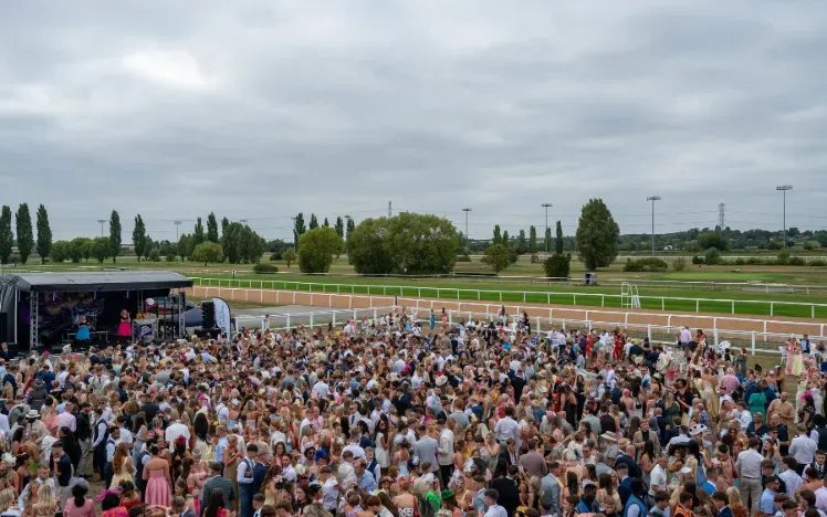 The crowd at Southwell Races gather in front of the live music stage.