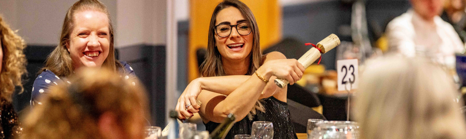 Woman pulling crackers and smiling.