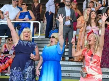 Three race goers cheering happily at Southwell