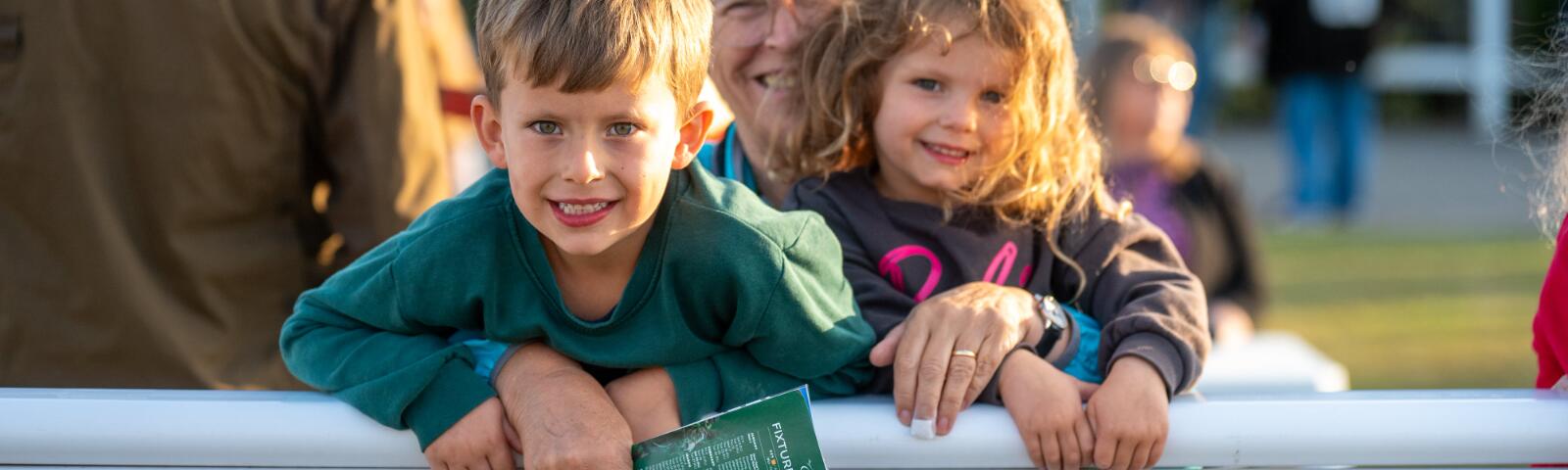 A family at the track side at Southwell, holding a racecard