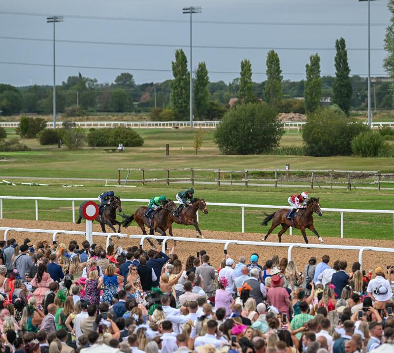 Horses race past the crowds at Southwell Racecourse