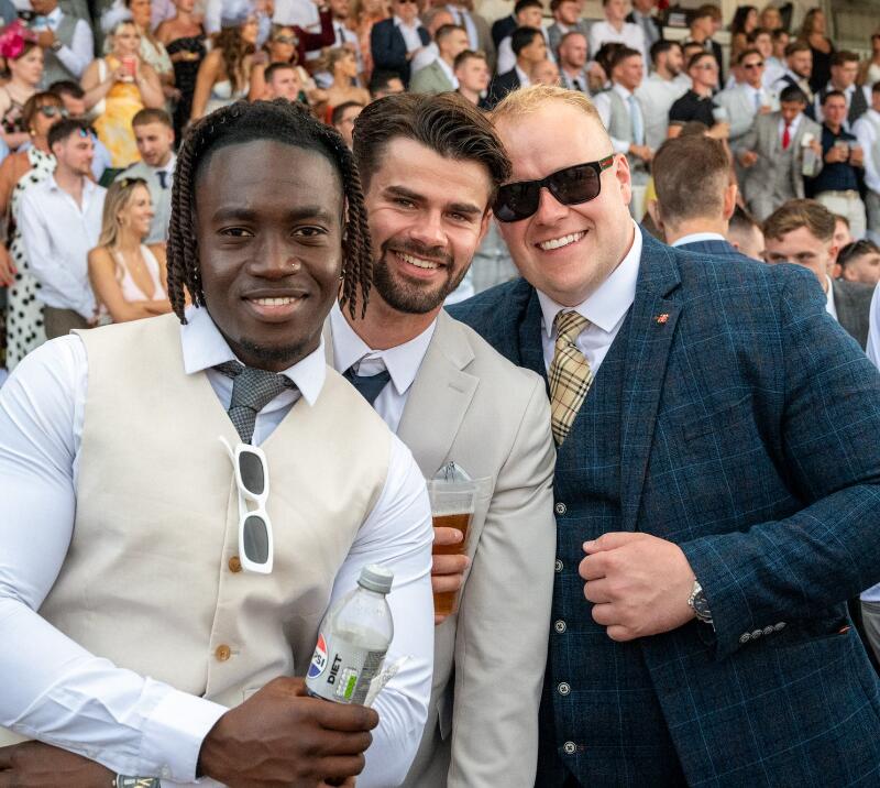 Three gents dressed for the races pos in front of the crowd at Southwell.