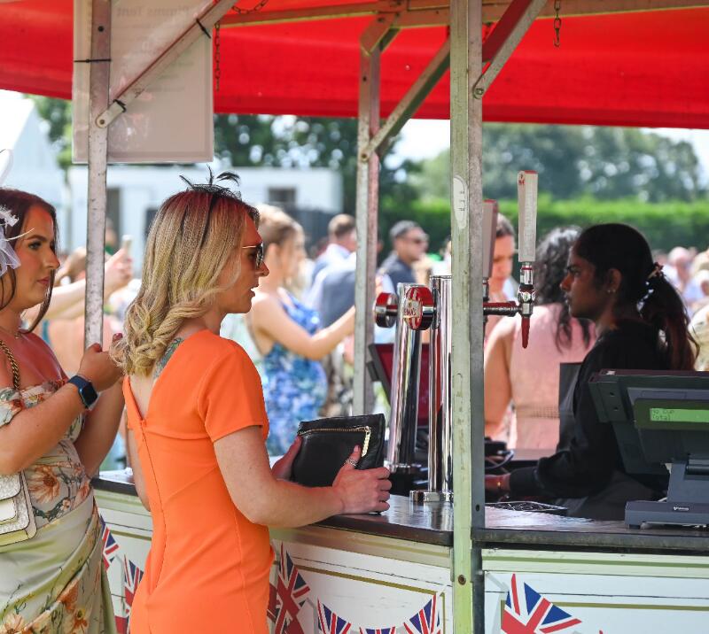 Visitors to Southwell Races being served drinks at an outdoor bar