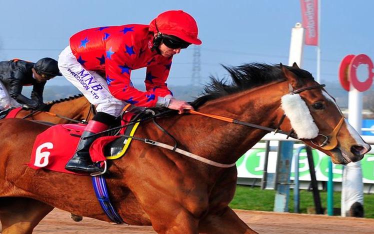 A Jockey on horseback runs past the finishing post.