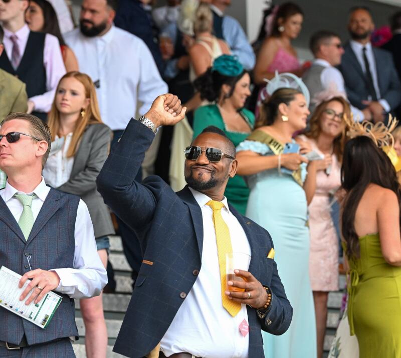A smartly dressed gent thrusting his arm in the air in celebration